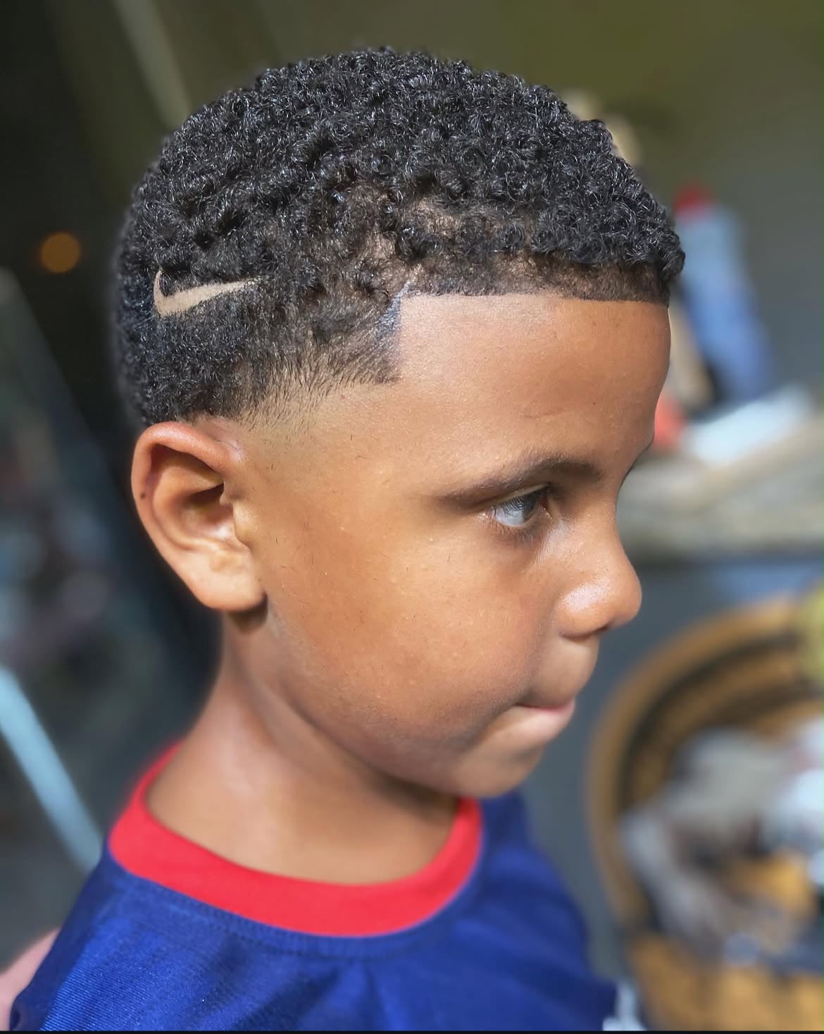 Corte infantil cacheado com desenho esportivo